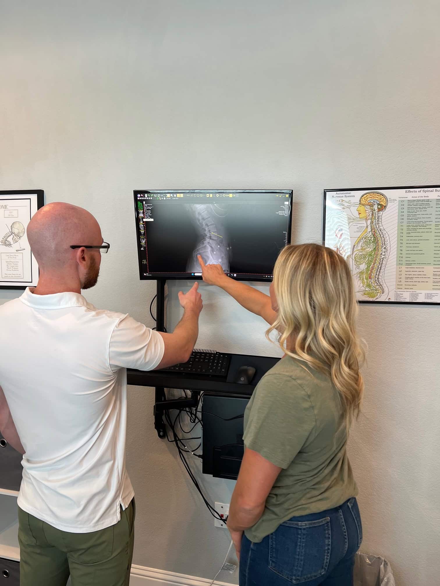Posture Correction 4 1. Chiropractor reviewing spinal x-ray with patient at Antignolo Chiropractic.